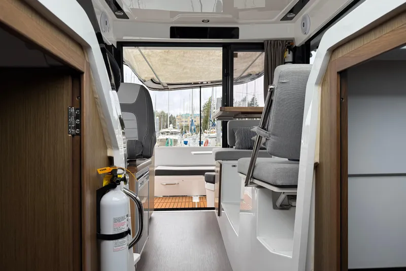  Yacht Photos Pics Interior view of 2020 Jeanneau NC 895 boat, featuring seating and a fire extinguisher.