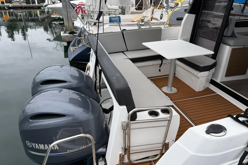  Yacht Photos Pics 2020 Jeanneau NC 895 boat with Yamaha engines, featuring a cozy seating area and table.