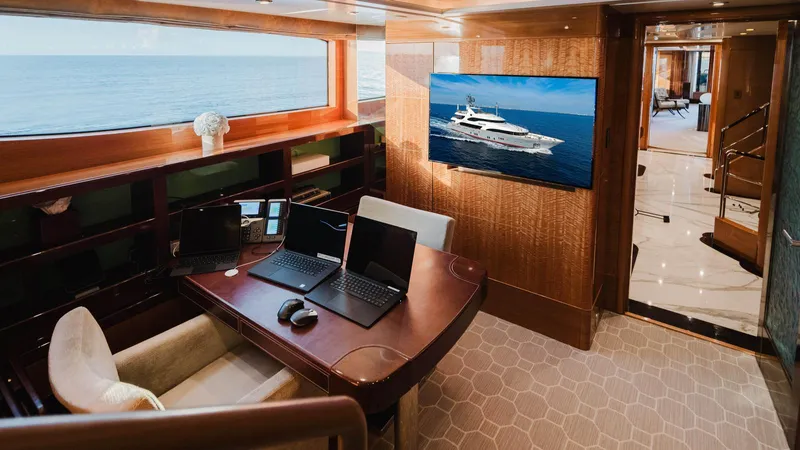 Groover Yacht Photos Pics Luxurious Benetti 145 yacht interior with office setup, featuring laptops and ocean view, 2009 model.