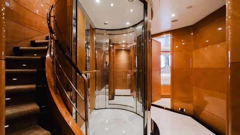 Groover Yacht Photos Pics Luxurious interior of 2009 Benetti 145 yacht with elegant staircase and polished wood finishes.