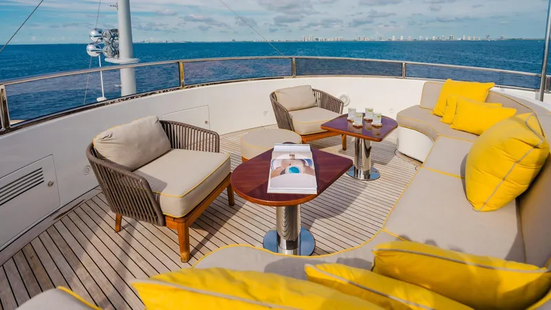 Groover Yacht Photos Pics Luxurious Benetti 145 yacht deck with comfortable seating, yellow cushions, and ocean view, 2009 model.