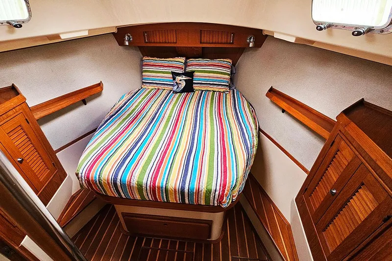  Yacht Photos Pics Cozy cabin interior of 2006 Island Packet 445 sailboat with striped bedding.