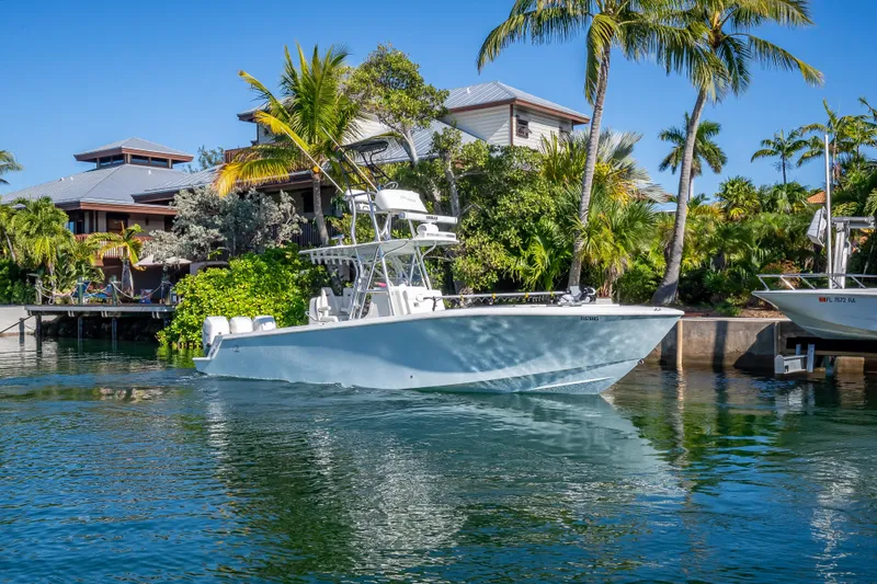  Yacht Photos Pics 2019 SeaVee 340Z boat docked near tropical waterfront homes, surrounded by lush palm trees.