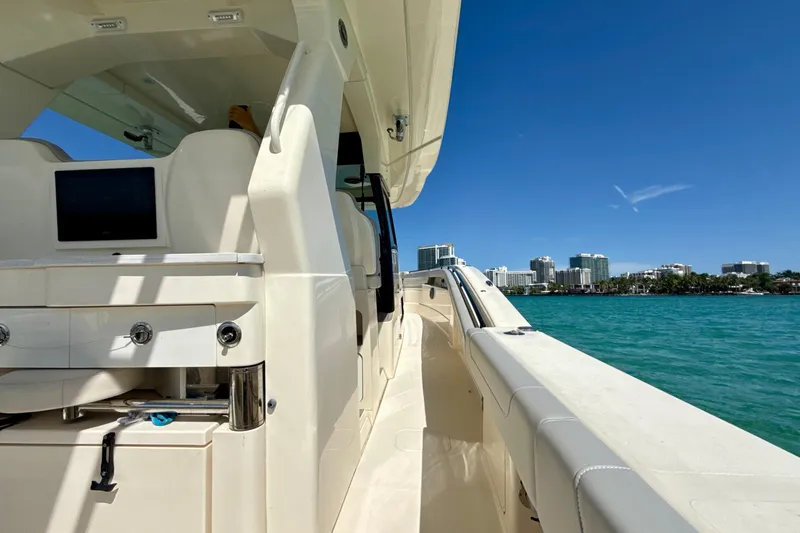  Yacht Photos Pics 2021 Scout 420 LXF boat cruising near city skyline on clear day.