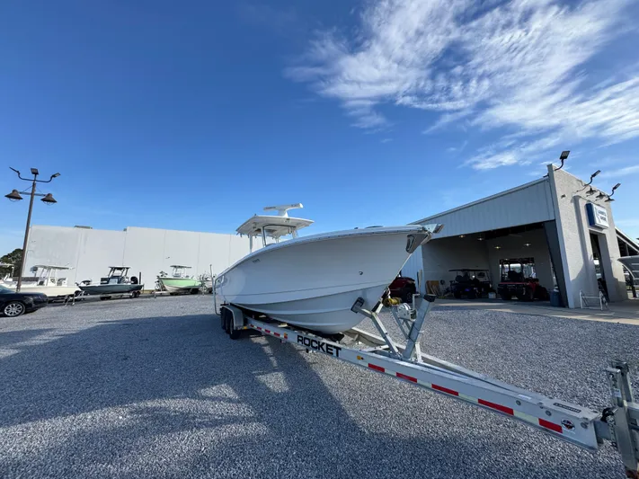  Yacht Photos Pics 2017 Edgewater 320CC boat on trailer outside dealership under blue sky.