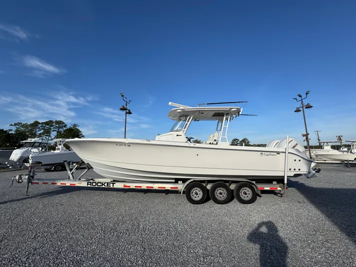  Yacht Photos Pics 2017 Edgewater 320CC boat on a trailer in a parking lot under clear blue sky.