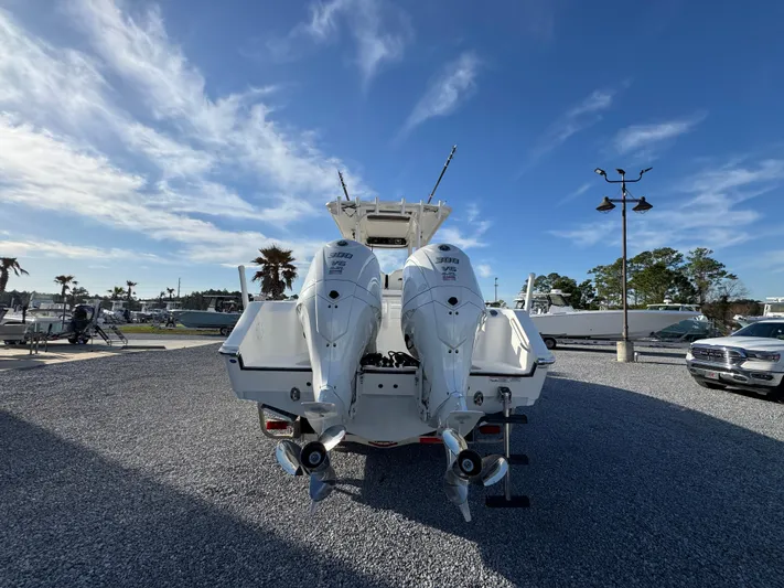  Yacht Photos Pics 2017 Edgewater 320CC boat with dual outboard motors on gravel lot under blue sky.