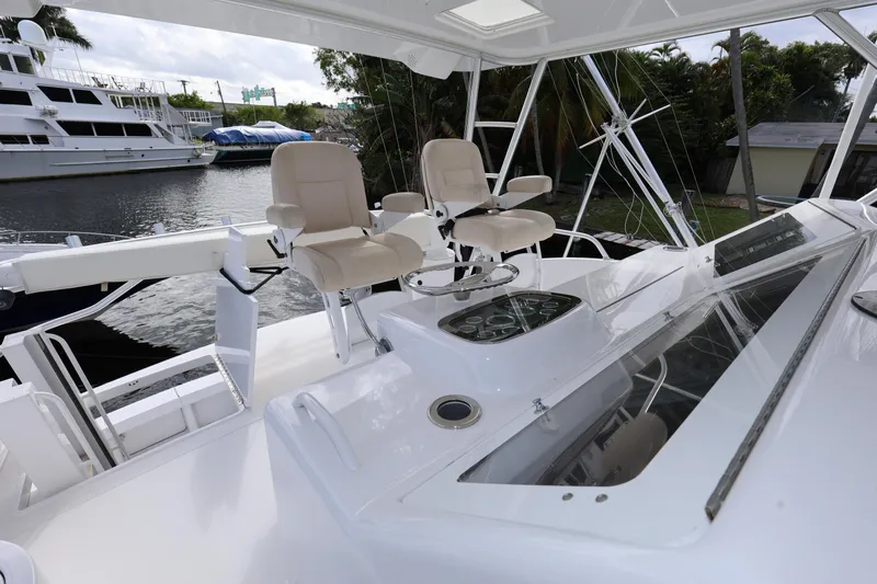  Yacht Photos Pics 2005 Viking 52 Convertible yacht helm with dual seats, docked near other boats.