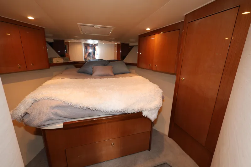  Yacht Photos Pics Interior cabin of 2005 Viking 52 Convertible yacht with cozy bed and wooden cabinetry.