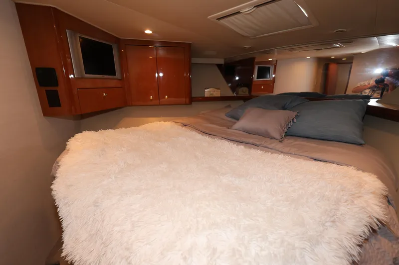  Yacht Photos Pics Luxurious bedroom interior of 2005 Viking 52 Convertible yacht with cozy bedding and TV.