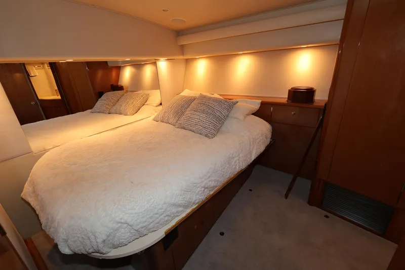  Yacht Photos Pics Luxurious bedroom interior of 2005 Viking 52 Convertible yacht with cozy lighting.