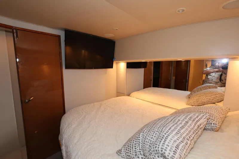 Yacht Photos Pics Interior of 2005 Viking 52 Convertible yacht bedroom with TV and cozy bedding.