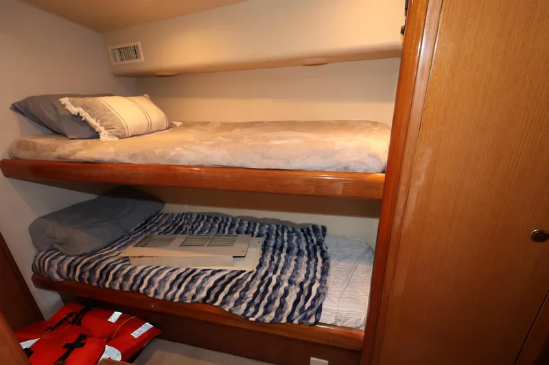  Yacht Photos Pics Bunk beds in 2005 Viking 52 Convertible yacht cabin, featuring cozy bedding and life jackets.