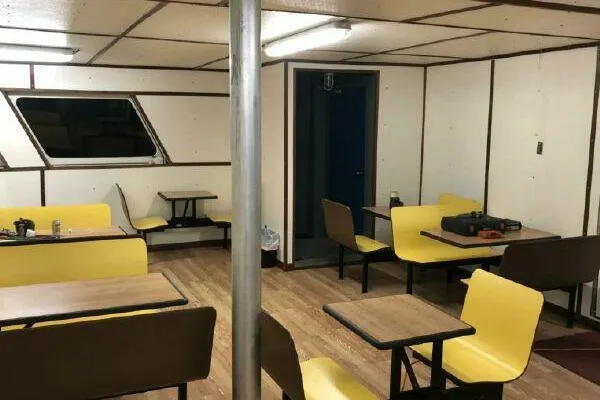 Southern Comfort Yacht Photos Pics Interior of AlumaCat 100, 2000 model, with yellow seating and wooden tables.