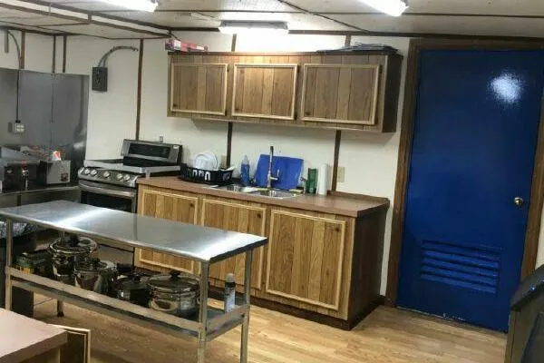 Southern Comfort Yacht Photos Pics Industrial kitchen with wooden cabinets, stainless steel appliances, and a blue door. AlumaCat 100, 2000.