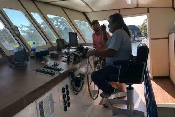 Southern Comfort Yacht Photos Pics Two people in AlumaCat 100 boat cockpit, 2000 model, navigating controls.