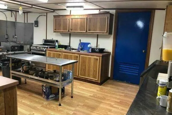 Southern Comfort Yacht Photos Pics Commercial kitchen with wooden cabinets, stainless steel table, and blue door, AlumaCat 100, 2000.
