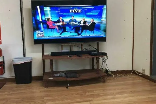 Southern Comfort Yacht Photos Pics TV showing news panel discussion in a living room with wooden flooring.