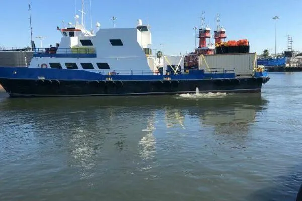 Southern Comfort Yacht Photos Pics AlumaCat 100 vessel from 2000 on calm waters, docked near industrial area.