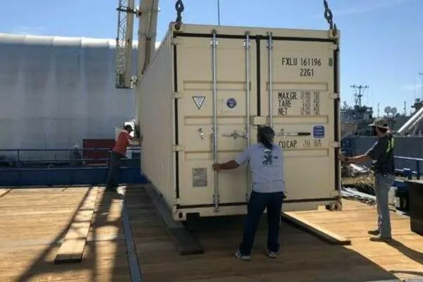 Southern Comfort Yacht Photos Pics Crane lifting AlumaCat 100 container, 2000 model, onto a wooden platform with workers assisting.