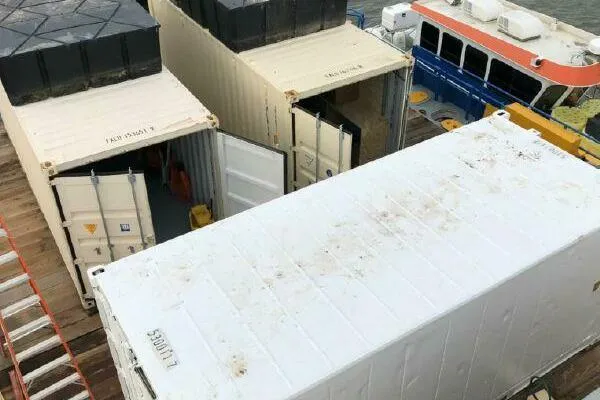 Southern Comfort Yacht Photos Pics Cargo containers on AlumaCat 100 vessel, 2000 model, docked near a boat.