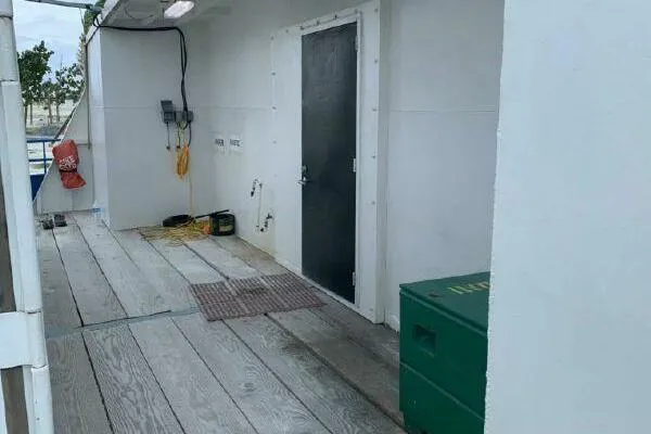 Southern Comfort Yacht Photos Pics AlumaCat 100 boat deck, 2000 model, featuring a black door and safety equipment.