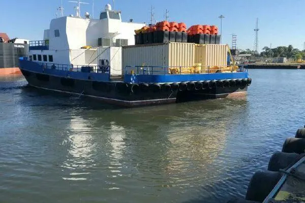 Southern Comfort Yacht Photos Pics AlumaCat 100 vessel from 2000 docked in a harbor, carrying cargo containers.