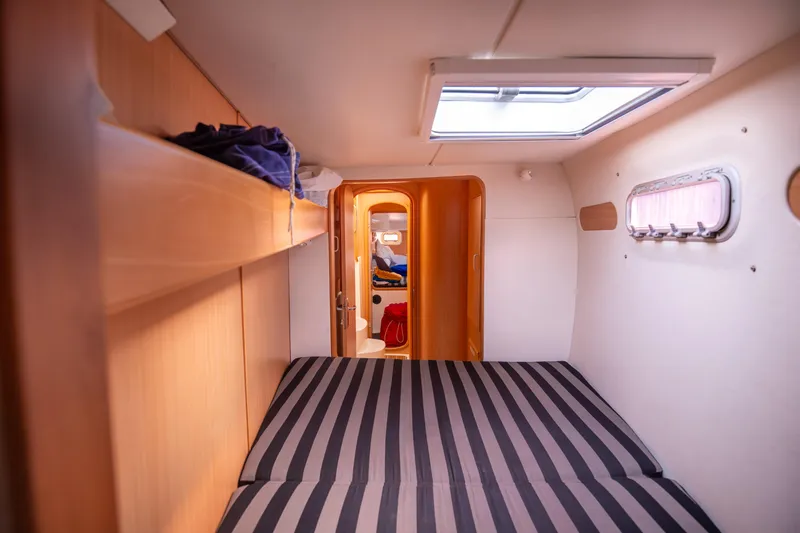  Yacht Photos Pics Cozy cabin interior of 2006 Leopard 40 catamaran with striped bedding and natural light.