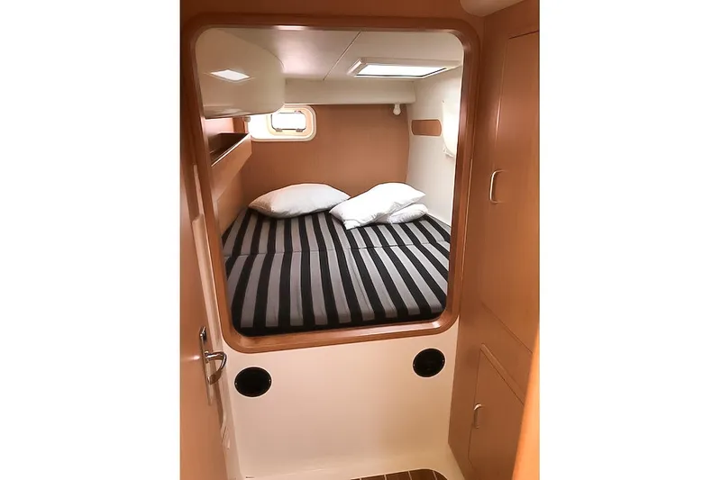  Yacht Photos Pics Cozy cabin interior of 2006 Leopard 40 catamaran with striped bedding and wooden finish.