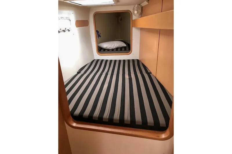  Yacht Photos Pics Cozy cabin interior of 2006 Leopard 40 with striped bedding and wooden accents.
