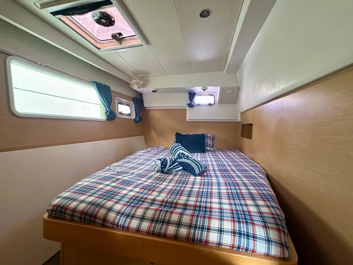 Selkie Yacht Photos Pics Cozy cabin interior of 2012 Lagoon 400 catamaran with plaid bedding and natural light.