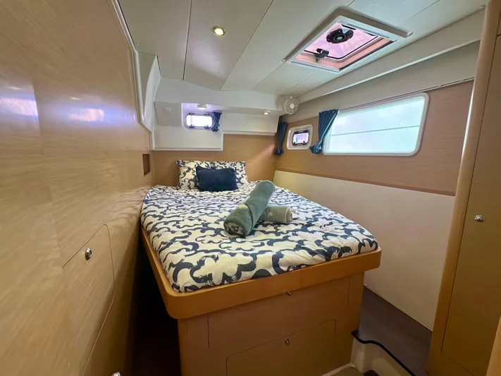 Selkie Yacht Photos Pics Cozy cabin interior of 2012 Lagoon 400 catamaran with bed and porthole windows.