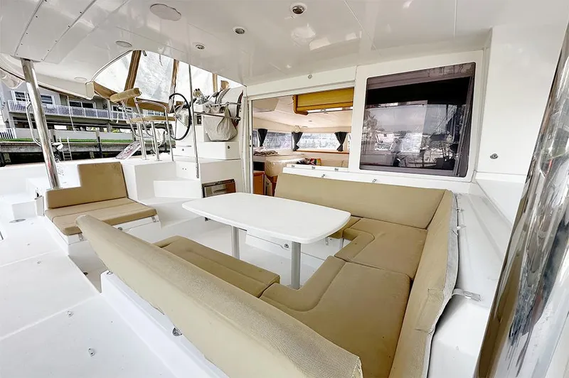 Selkie Yacht Photos Pics Spacious 2012 Lagoon 400 catamaran cockpit with beige seating and white table.