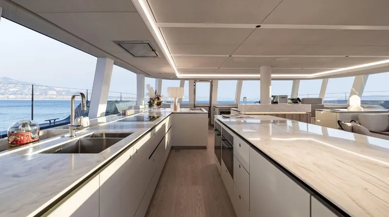 Apollo 99 Yacht Photos Pics Luxurious interior of 2023 Sunreef 80 Eco yacht with modern kitchen and ocean view.