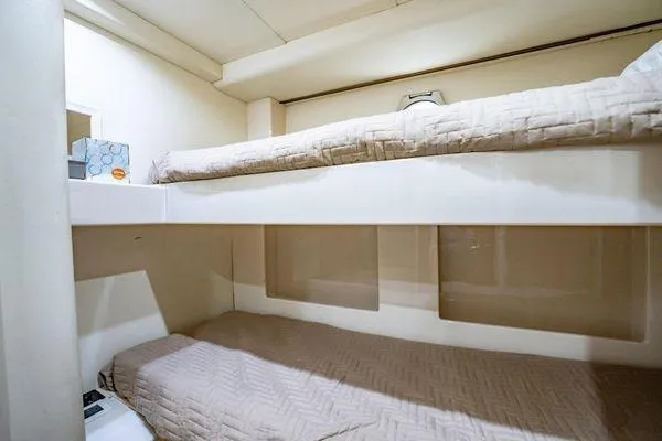 The Cure Yacht Photos Pics Bunk beds in 2003 Azimut 80 Carat yacht cabin, featuring beige bedding and compact design.