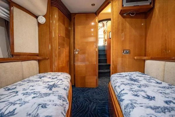 The Cure Yacht Photos Pics Luxurious 2003 Azimut 80 Carat yacht cabin with twin beds and elegant wood paneling.