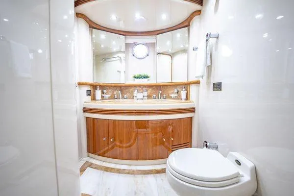 The Cure Yacht Photos Pics Luxurious bathroom on 2003 Azimut 80 Carat yacht with elegant wood cabinetry and modern fixtures.