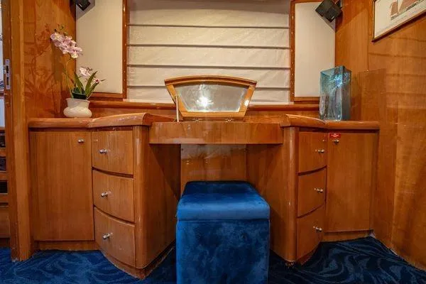 The Cure Yacht Photos Pics Luxurious wooden vanity area on 2003 Azimut 80 Carat yacht with blue stool and decor.