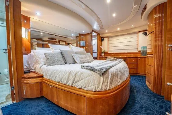 The Cure Yacht Photos Pics Luxurious bedroom interior of 2003 Azimut 80 Carat yacht with elegant wood finishes.