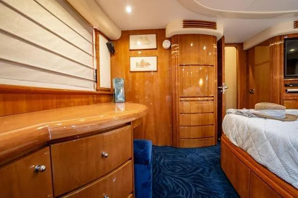The Cure Yacht Photos Pics Luxurious interior of 2003 Azimut 80 Carat yacht with elegant wood finishes and plush bedding.