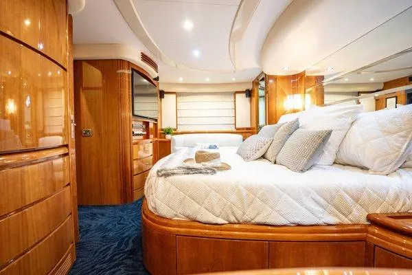 The Cure Yacht Photos Pics Luxurious bedroom interior of 2003 Azimut 80 Carat yacht with elegant wood finishes.