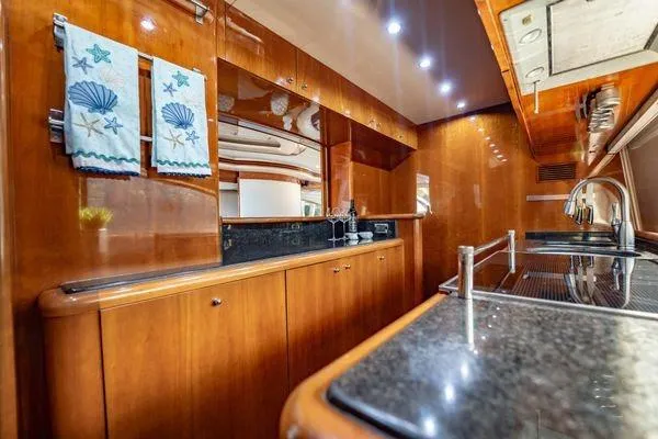 The Cure Yacht Photos Pics Luxurious kitchen interior of 2003 Azimut 80 Carat yacht with wood finish and modern amenities.