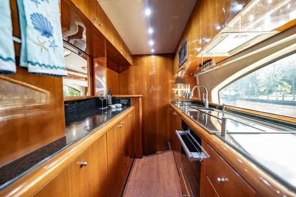 The Cure Yacht Photos Pics Luxurious kitchen interior of 2003 Azimut 80 Carat yacht with wood cabinetry and modern appliances.