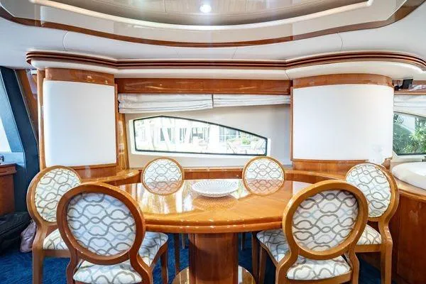 The Cure Yacht Photos Pics Luxurious dining area on 2003 Azimut 80 Carat yacht with elegant wooden table and chairs.