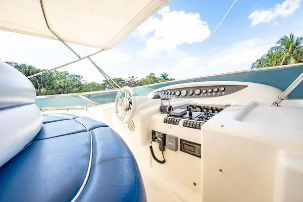 The Cure Yacht Photos Pics Luxurious 2003 Azimut 80 Carat yacht helm with blue seating and tropical backdrop.