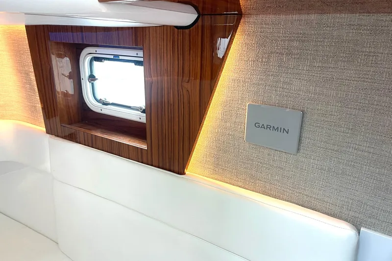  Yacht Photos Pics 2024 HCB 48 Campeon interior with wood accents, window, and Garmin panel.