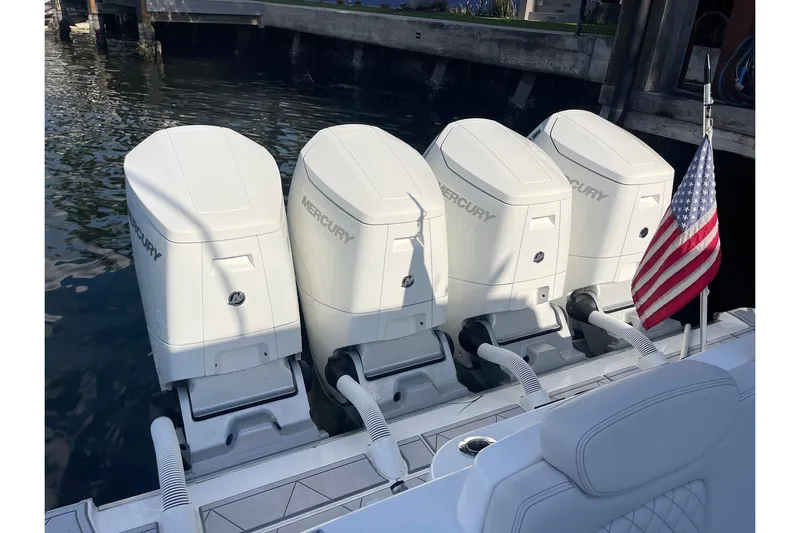  Yacht Photos Pics Four Mercury outboard engines on a 2024 HCB 48 Campeon boat, docked with an American flag.