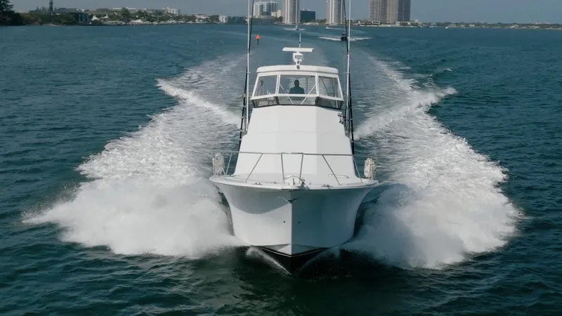 Denise Catherine Yacht Photos Pics 1991 Jersey 42 Convertible Sportfisherman cruising on open water, creating a dynamic wake.