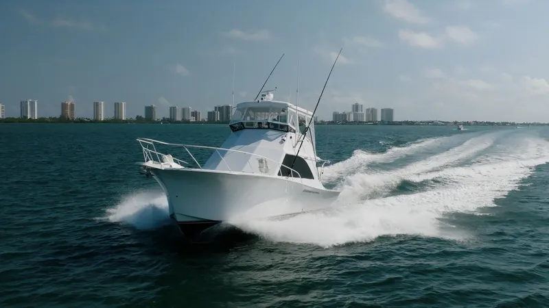 Denise Catherine Yacht Photos Pics 1991 Jersey 42 Convertible Sportfisherman cruising on open water, city skyline in background.