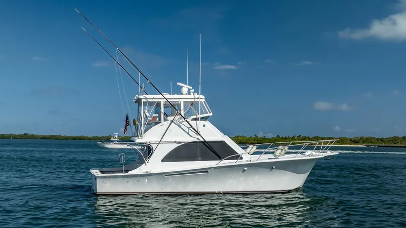 Denise Catherine Yacht Photos Pics 1991 Jersey 42 Convertible Sportfisherman boat on calm water under clear blue sky.